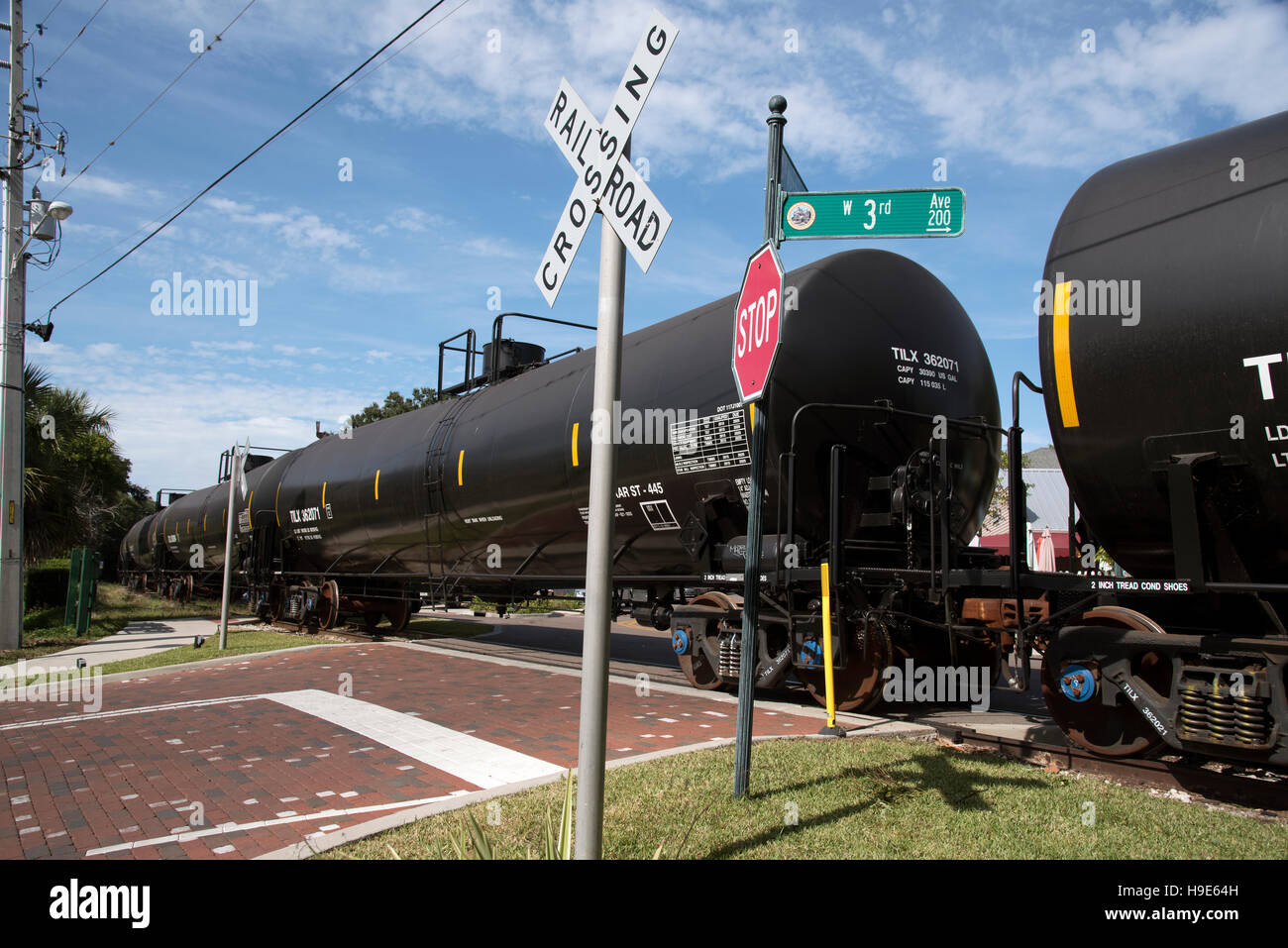 Mount Dora Florida USA -  Railroad freight train hauling liquid carrying trucks passing over unmanned crossing Stock Photo