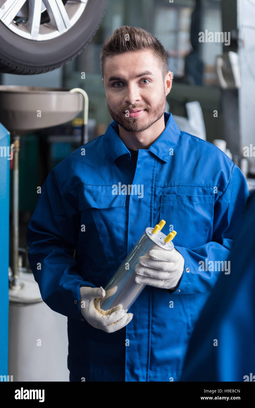 Positive man holding oil filter Stock Photo Alamy