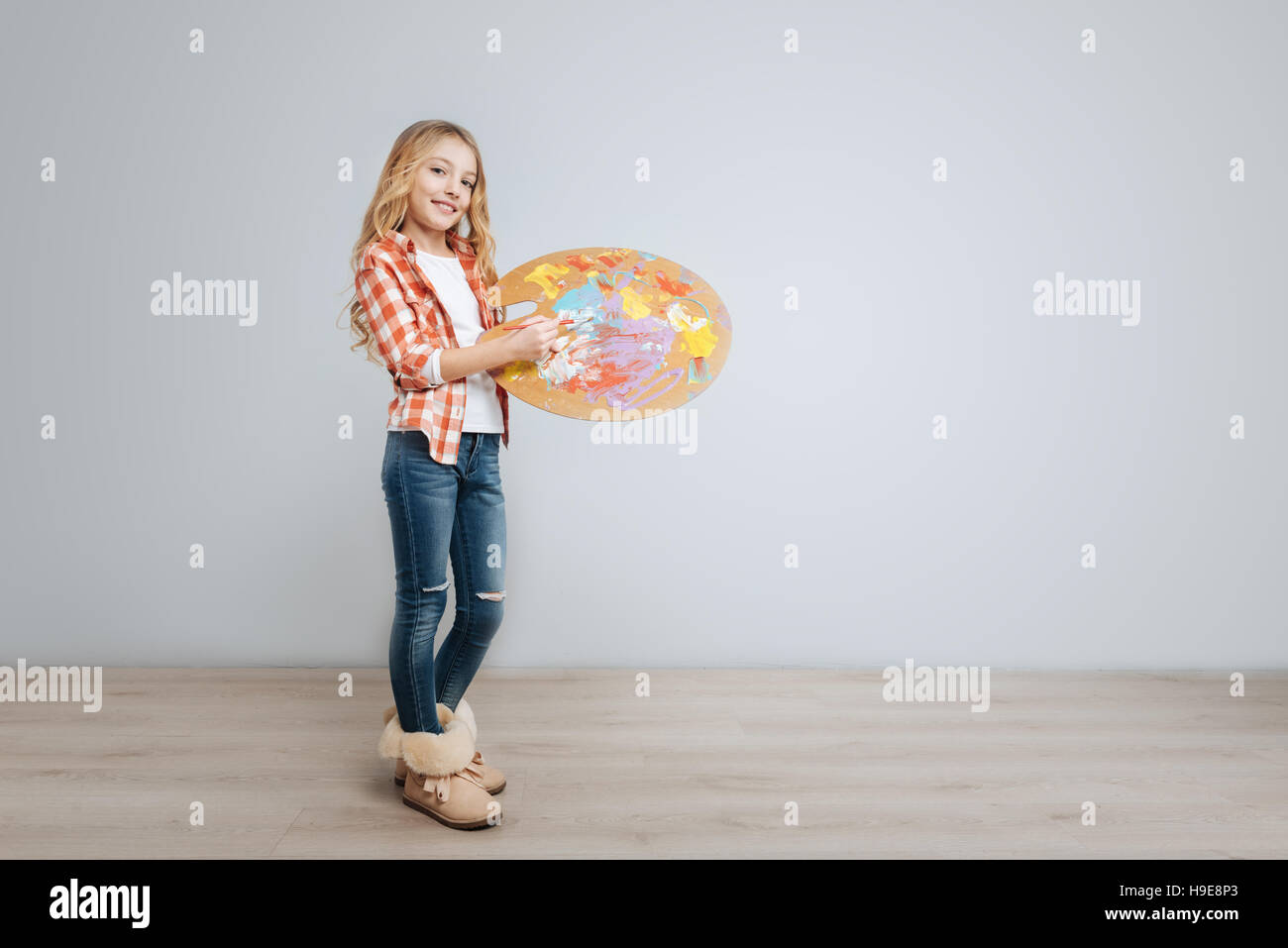 Pleasant little girl holding color palette Stock Photo - Alamy