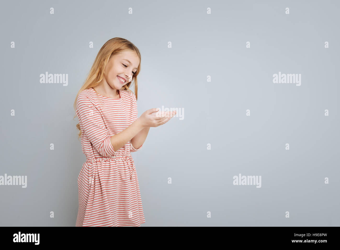 Little cute girl standing isolated on grey background Stock Photo - Alamy