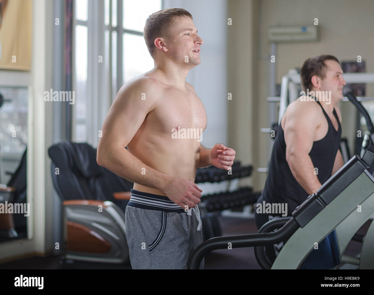 Two young athlete in the gym running on a treadmill Stock Photo