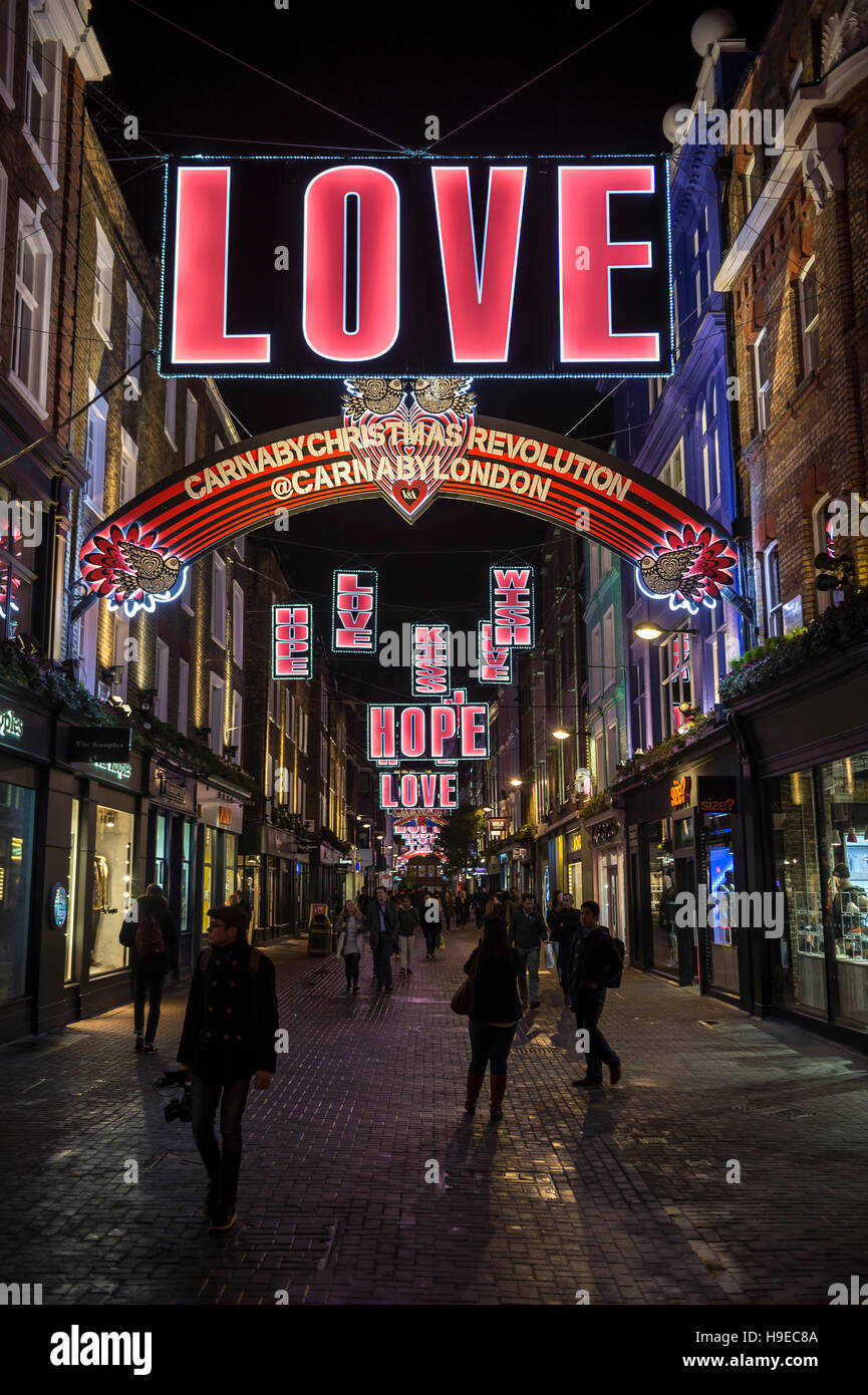 LONDON - NOVEMBER 16, 2016: Christmas holiday signs of love, hope, and affection decorate the shopping center of Carnaby Street. Stock Photo