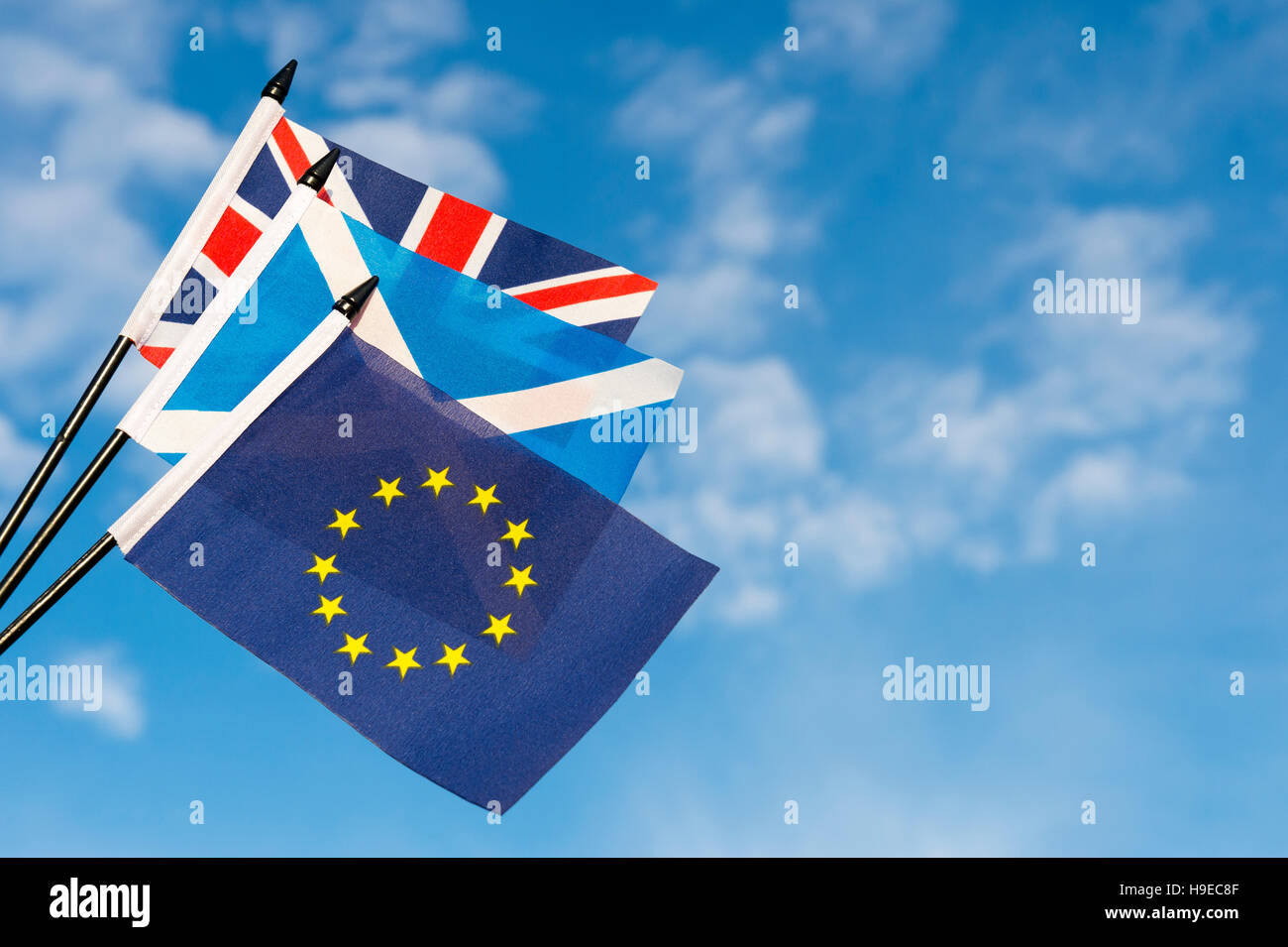 Scottish, UK, and EU flags flying together in bright blue sky Stock Photo