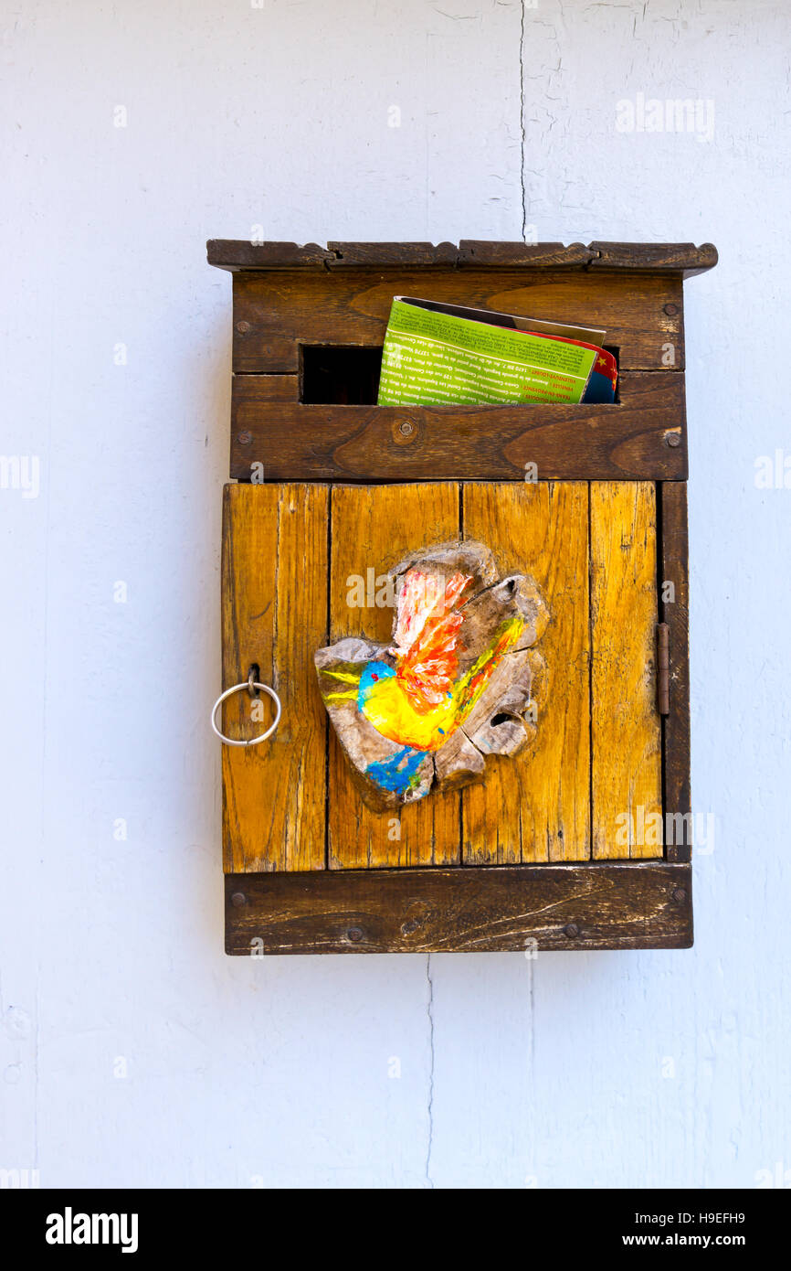 A mailbox in France with colourful mail sticking out. Seen in the village of Ramatuelle, South
