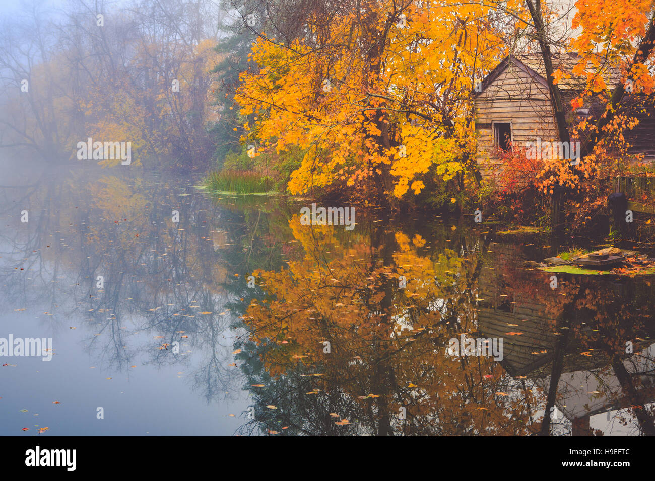 An old canal house on the Delaware and Raritan Canal reflects on a calm autumn morning. Stock Photo