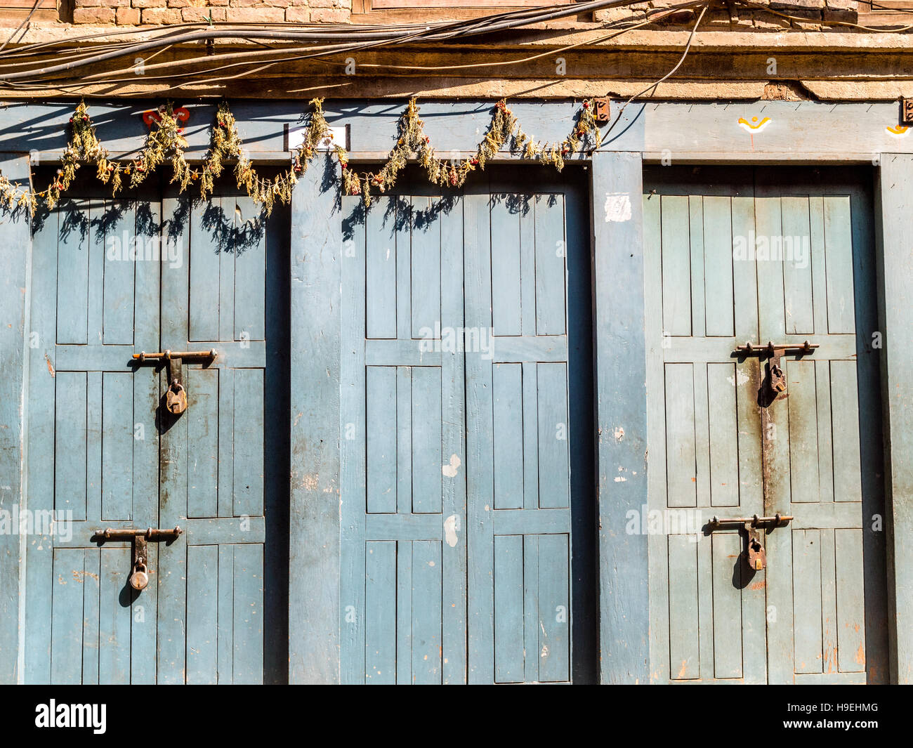 Padlocked doors at Bhaktapur, Nepal with wires and garland Stock Photo