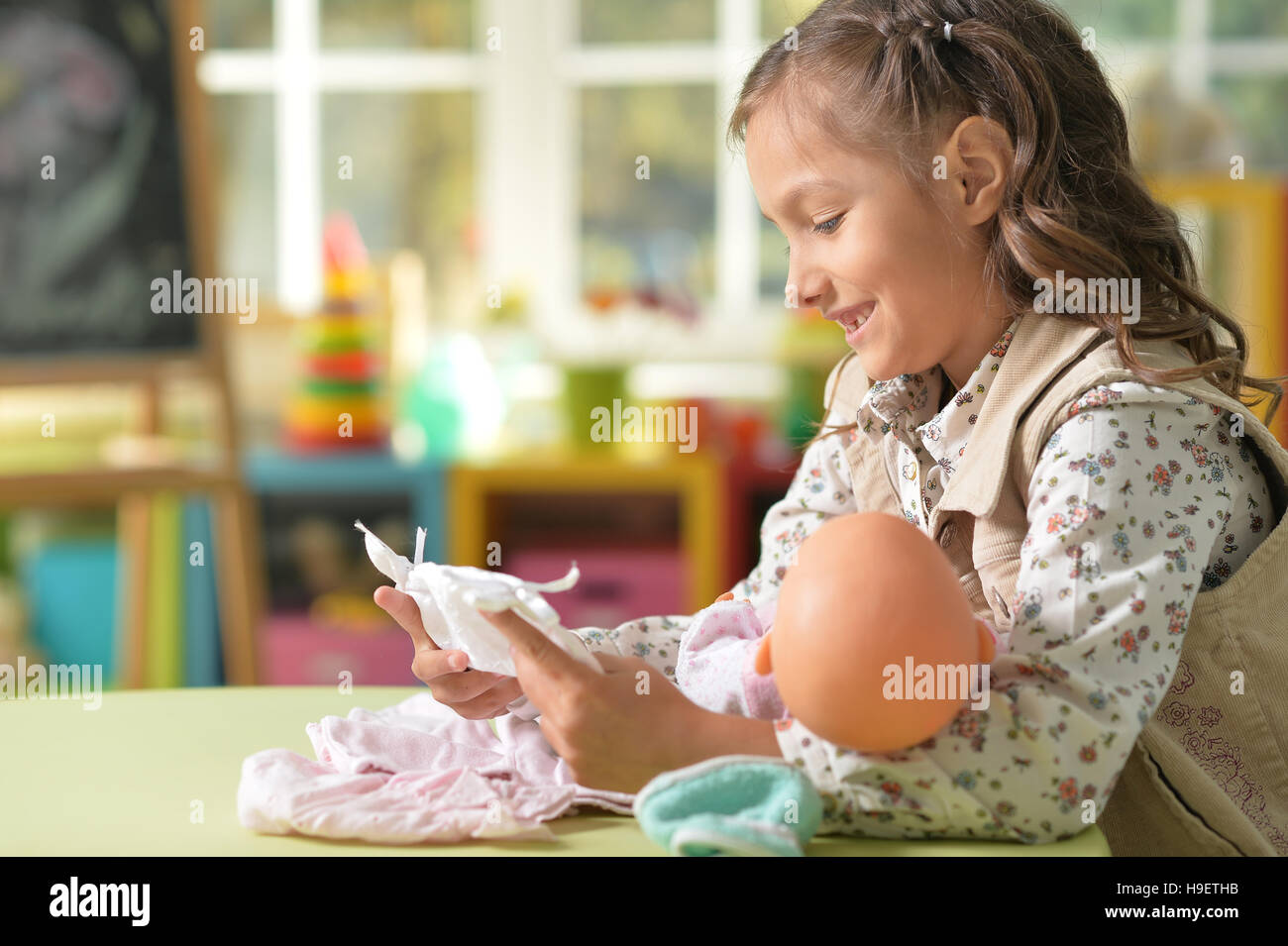 Girl playing with baby doll Stock Photo - Alamy