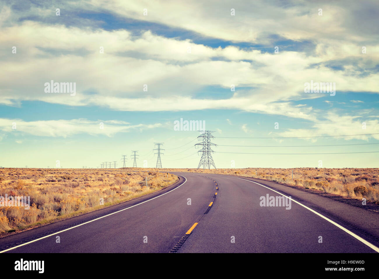 Vintage toned empty rural highway with electric poles. Stock Photo