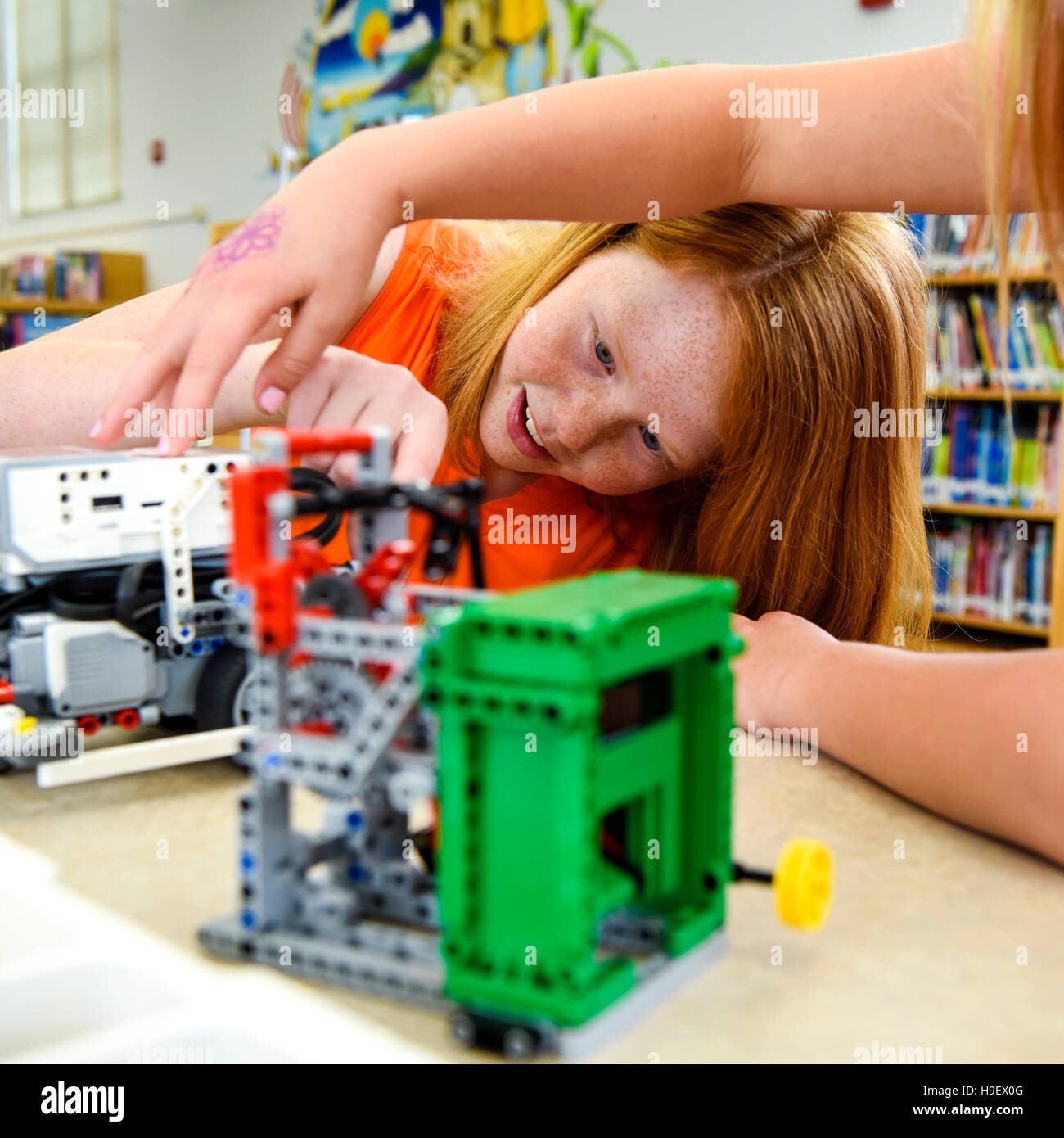 Girls assembling plastic blocks in library Stock Photo Alamy