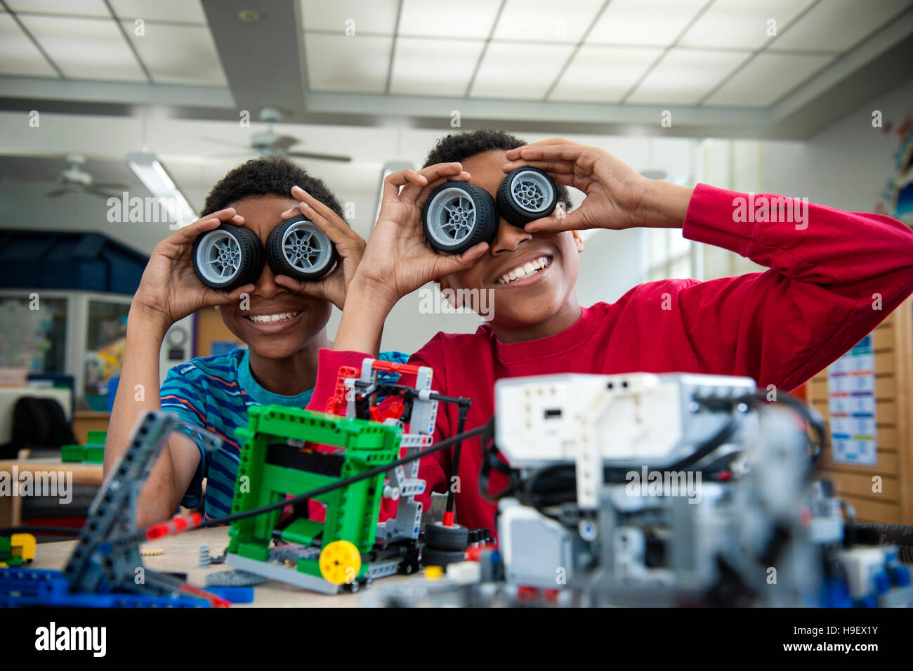 Boys playing with toy wheels in library Stock Photo