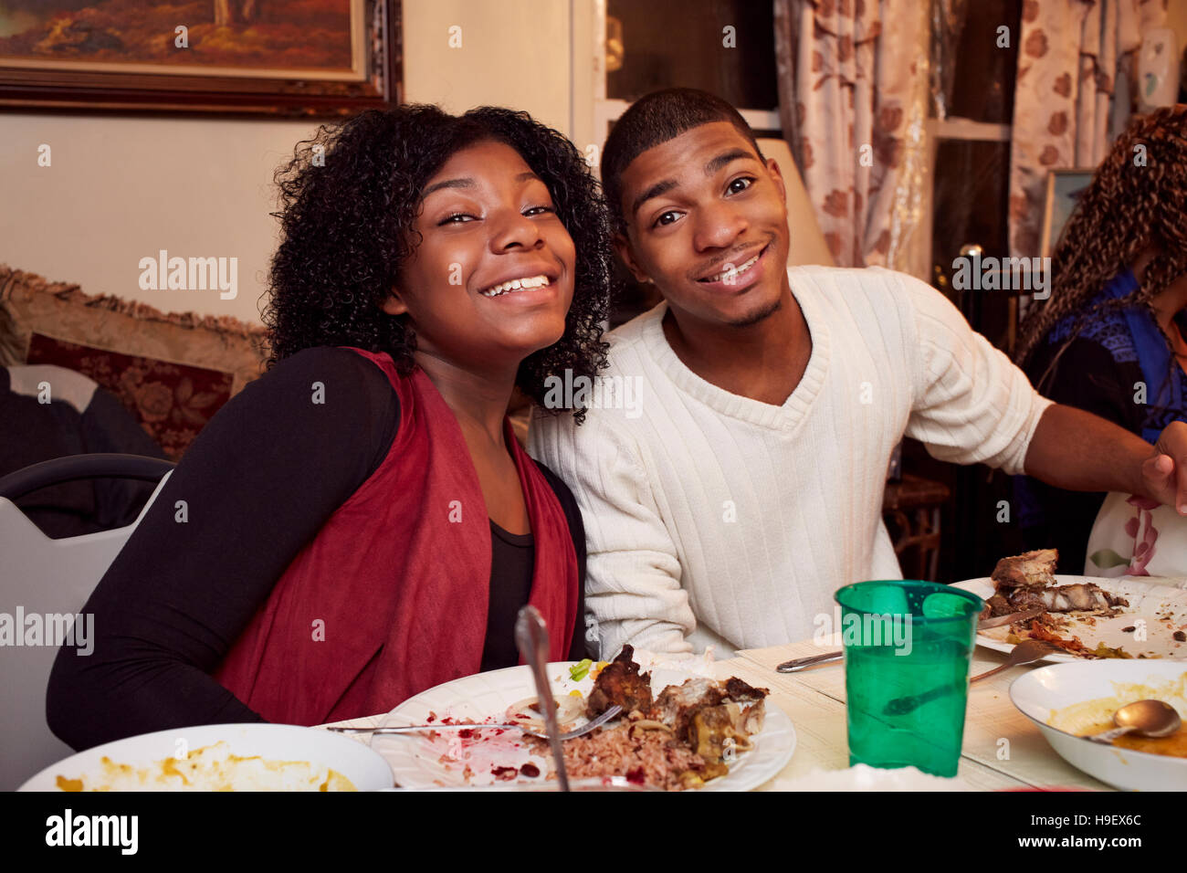 Smiling Black brother and sister at dinner table Stock Photo