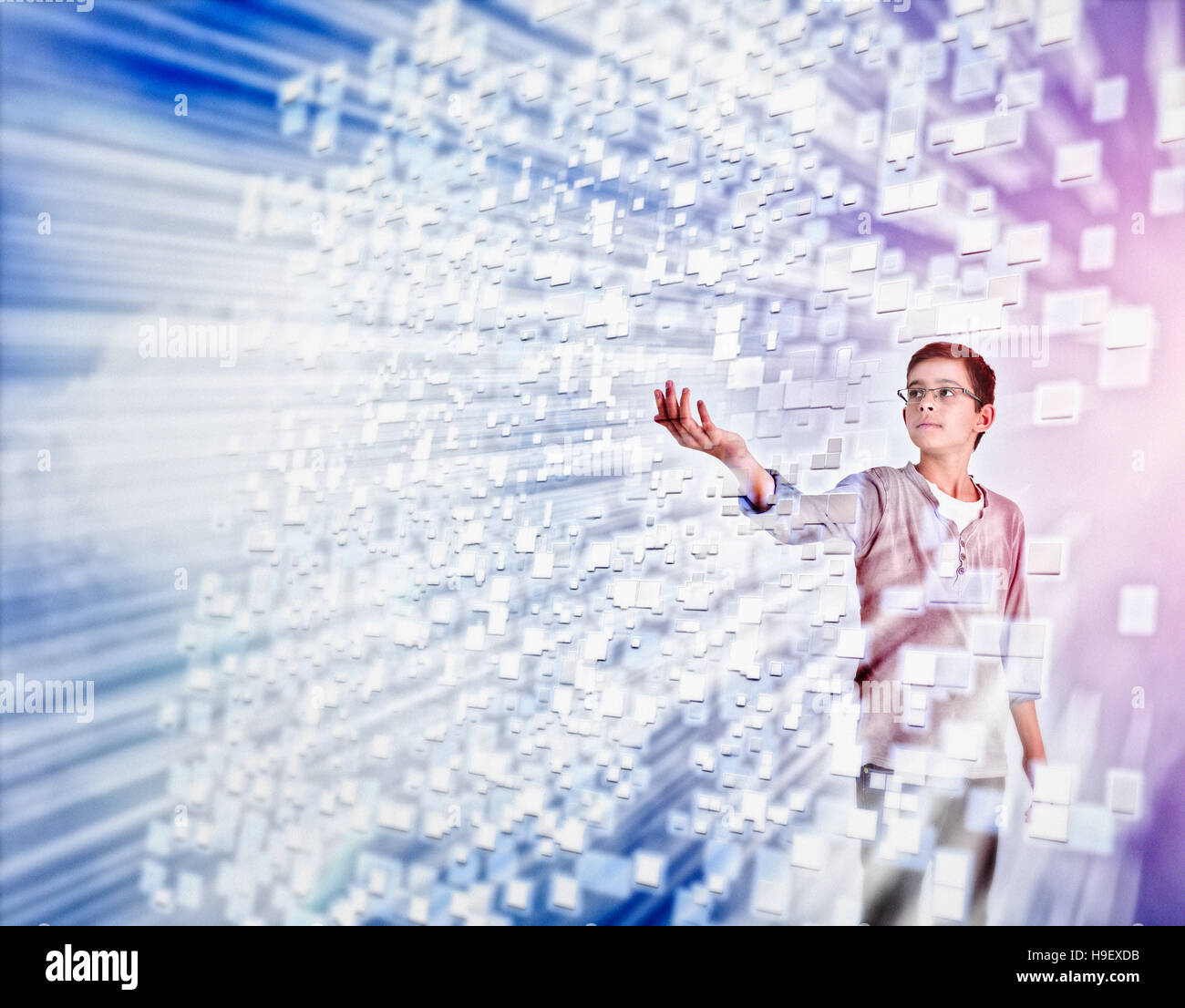 Mixed Race boy reaching for hovering pixels Stock Photo