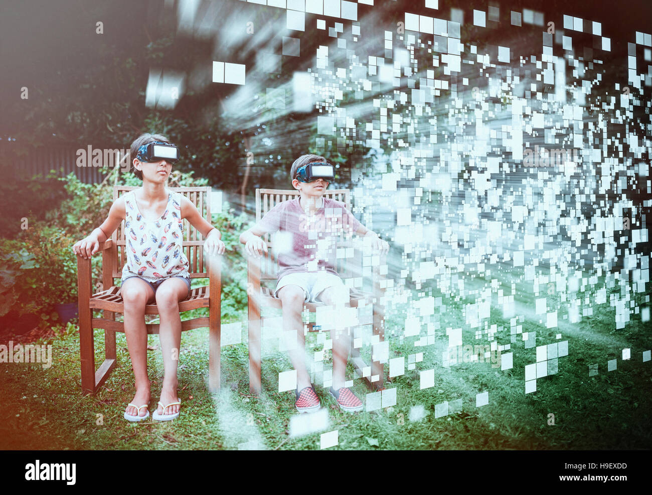 Mixed Race brother and sister viewing hovering pixels with vr goggles Stock Photo