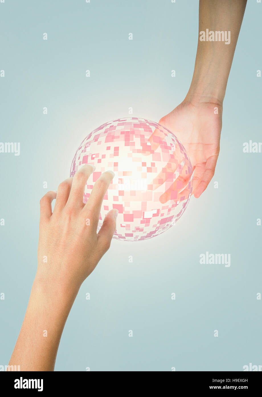 Hands of Mixed Race boy holding glowing pixel sphere Stock Photo