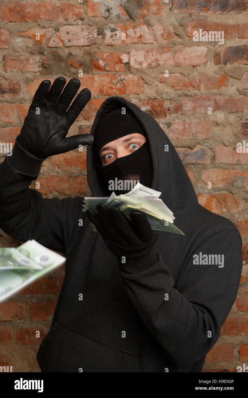 Robber in mask throws banknotes Stock Photo Alamy