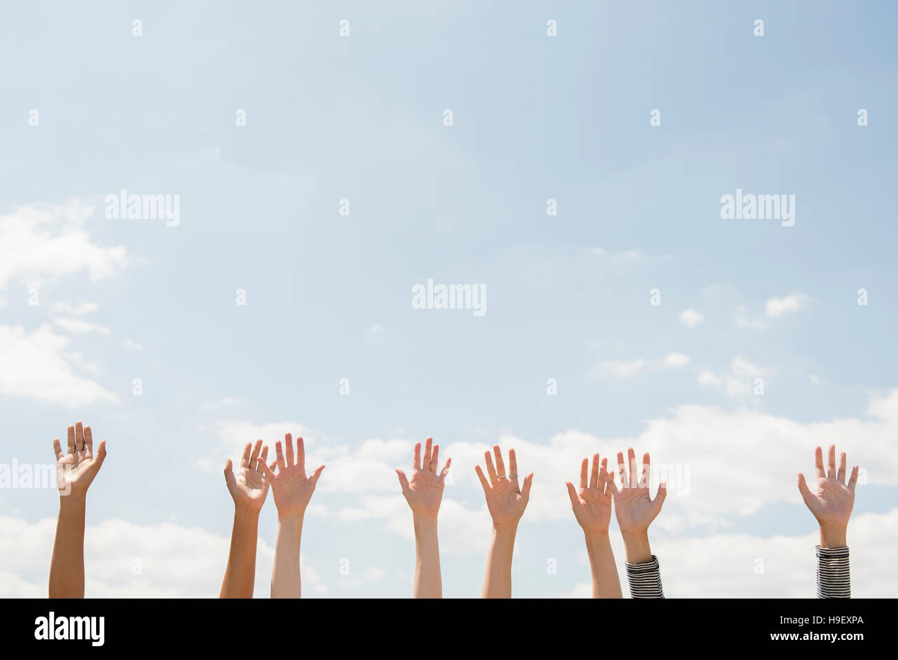 Raised hands of women outdoors Stock Photo