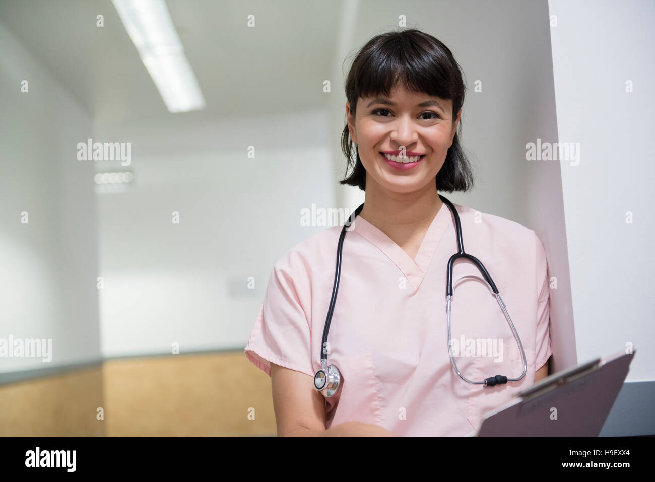 Smiling Hispanic nurse holding clipboard Stock Photo - Alamy