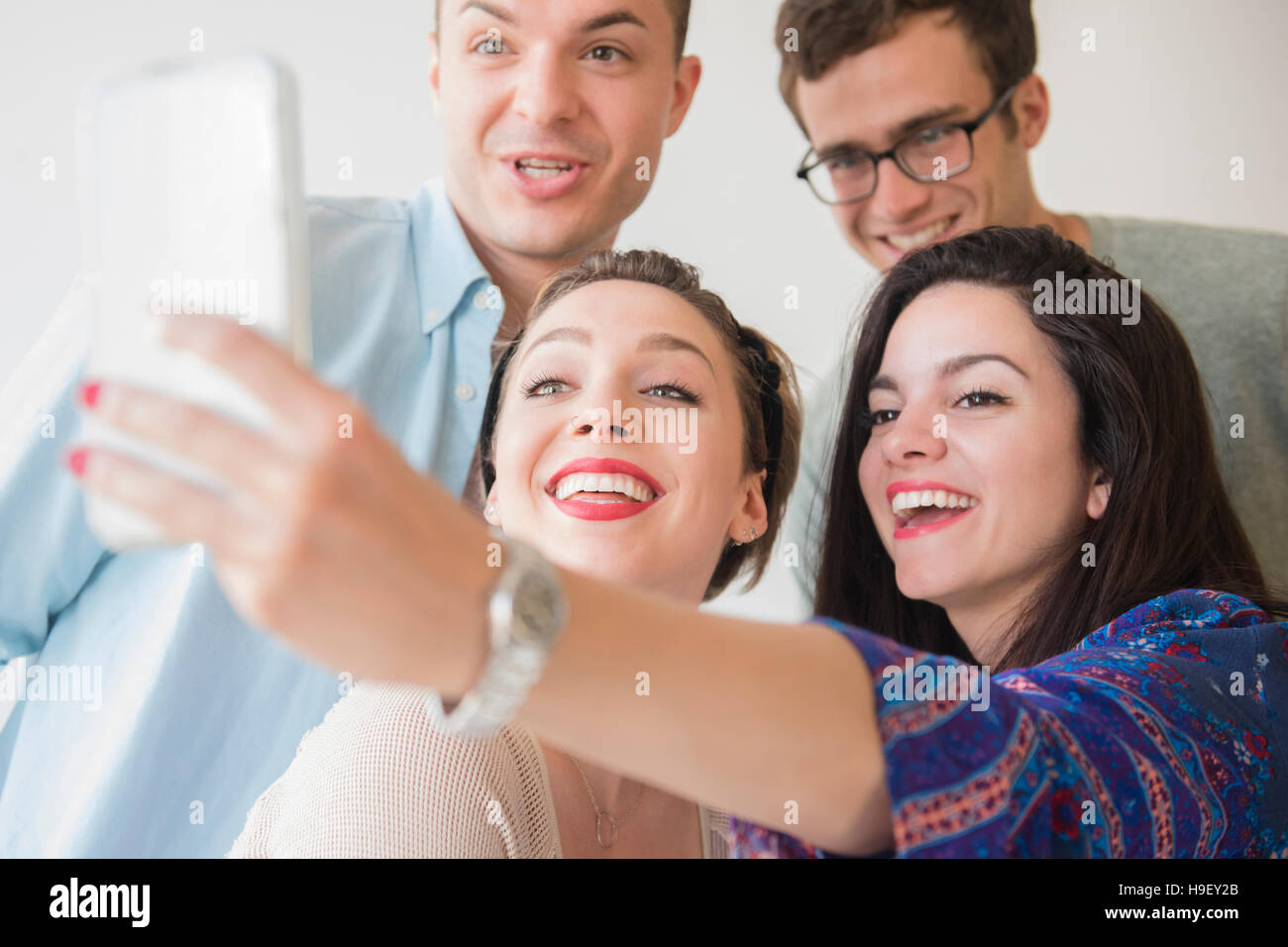 Smiling Caucasian friends posing for cell phone selfie Stock Photo