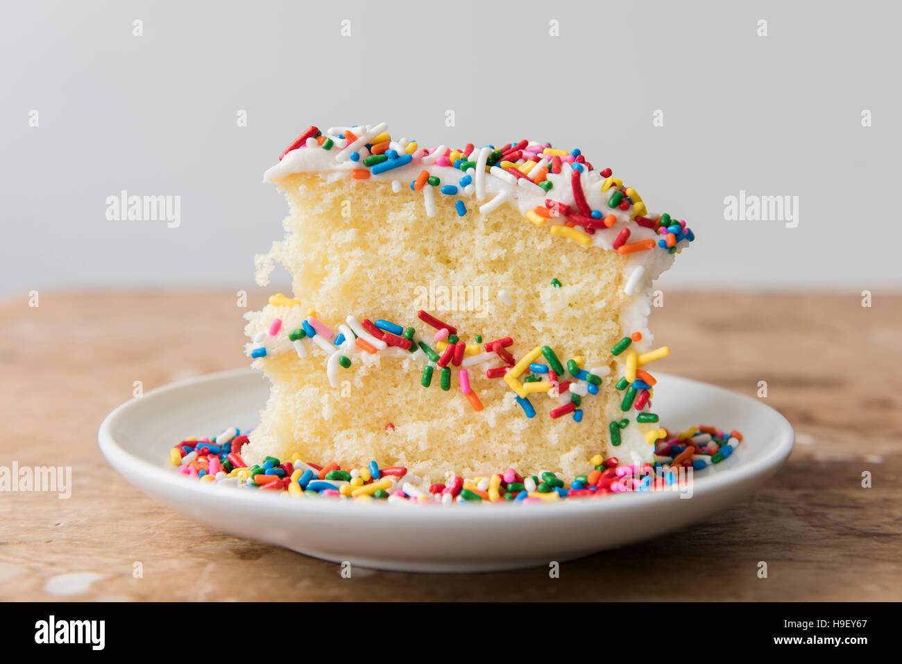 Slice of cake with sprinkles on plate Stock Photo