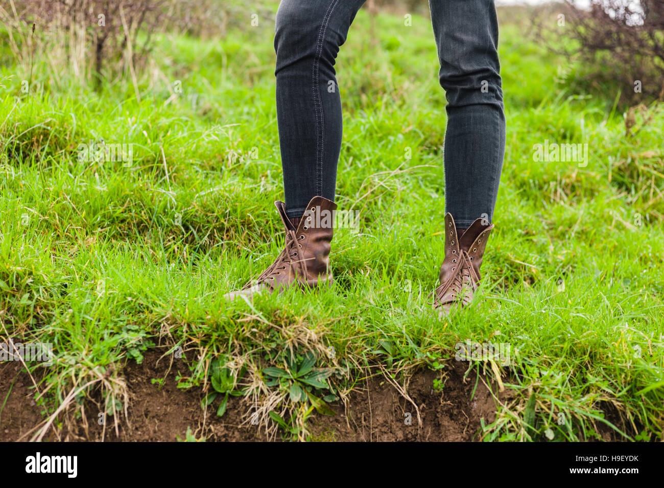 The feet of a young person wearing boots in nature Stock Photo - Alamy