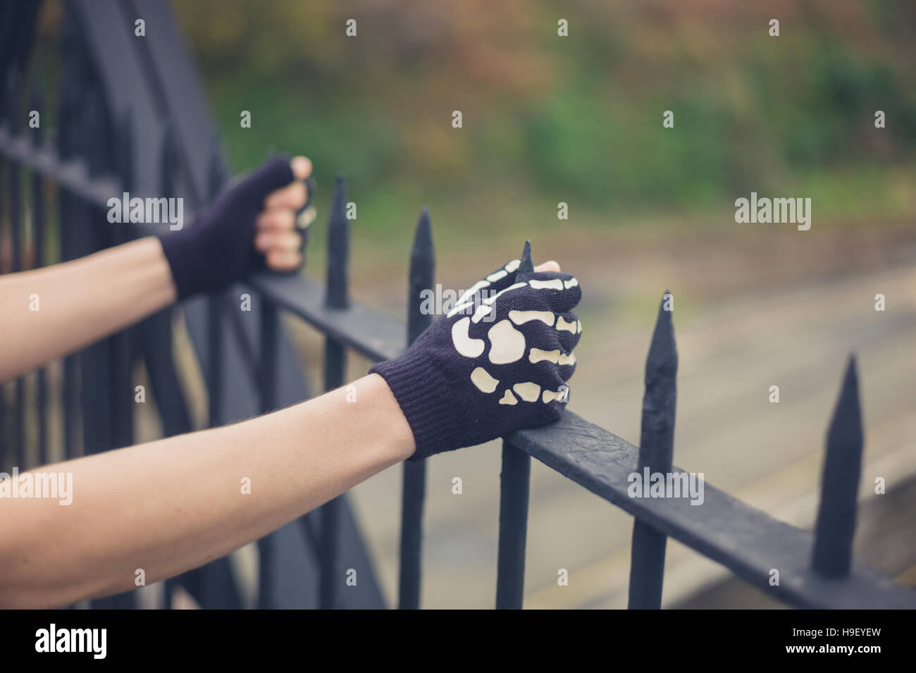 The gloved hands of a young person is grabbing some railings Stock Photo