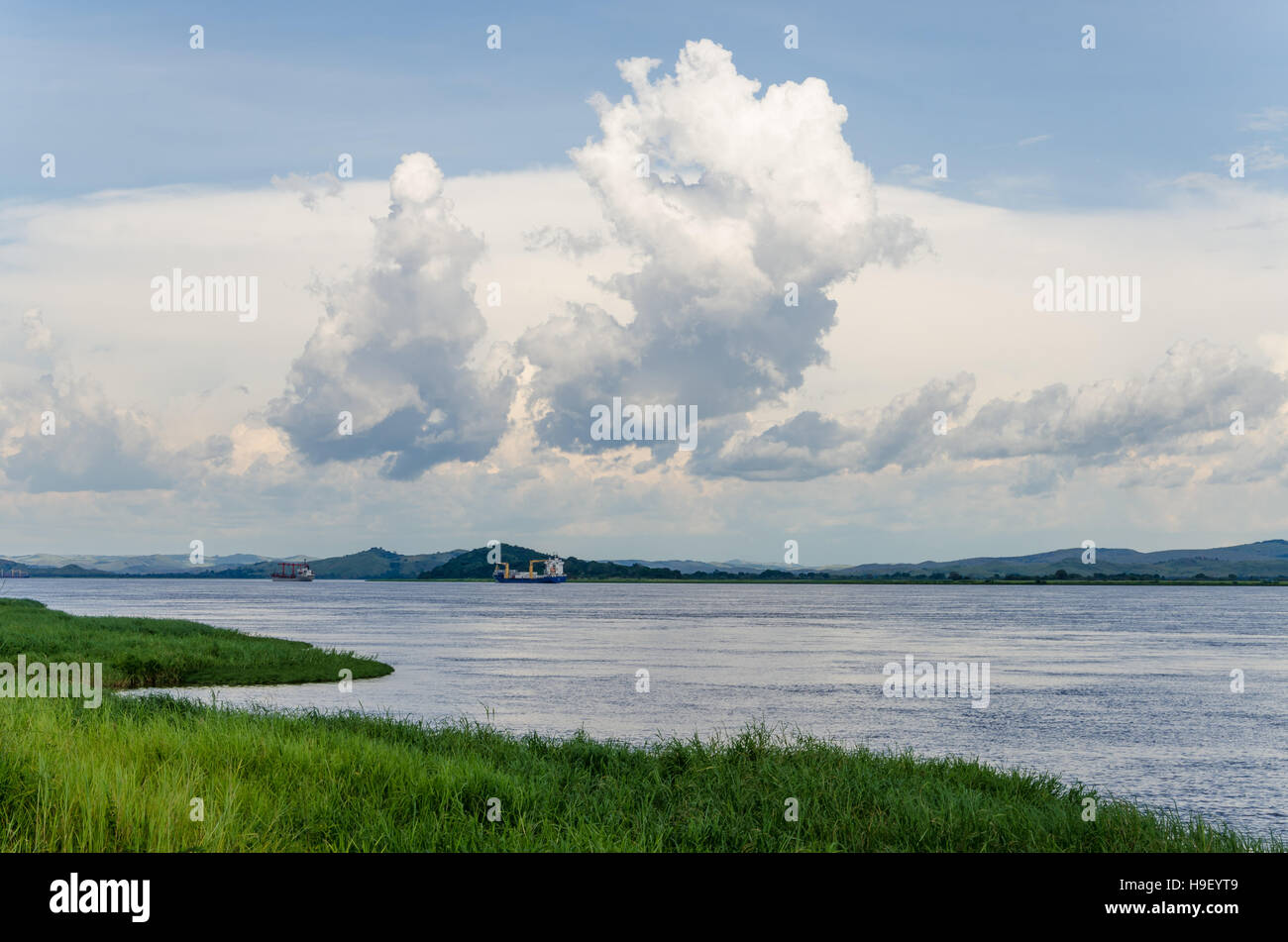 Container cargo ships on mighty Congo river with dramatic sky Stock Photo