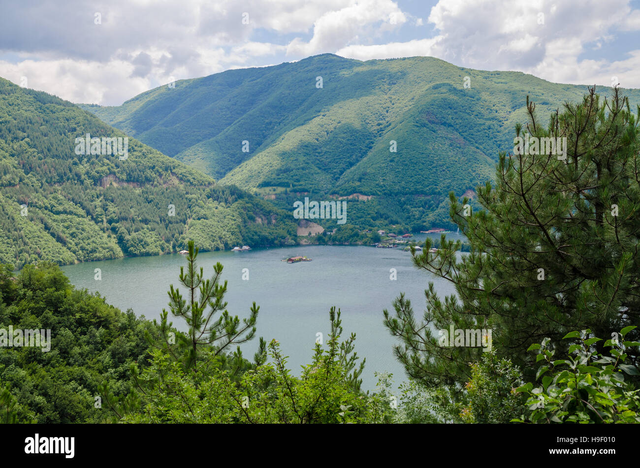Wide calm river running through green forested hills in southern Bulgaria Stock Photo