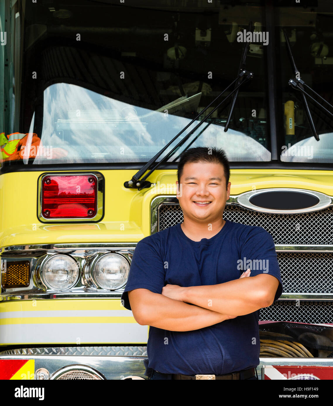 Smiling Chinese fireman posing with fire truck Stock Photo