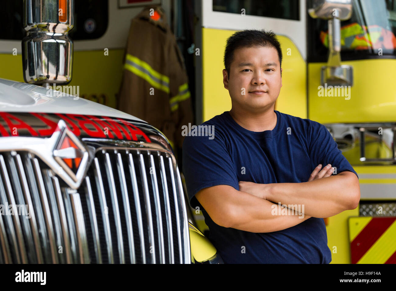 Serious Chinese fireman posing with fire truck Stock Photo