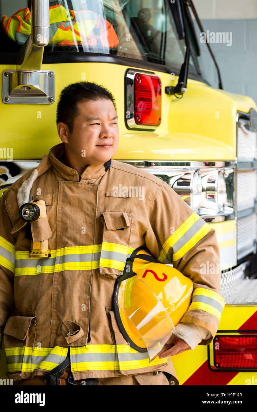 Chinese fireman standing near fire trucks Stock Photo