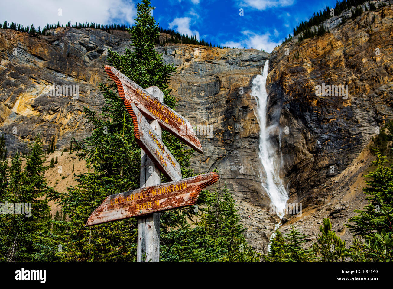 Sign near waterfall flowing over cliff Stock Photo