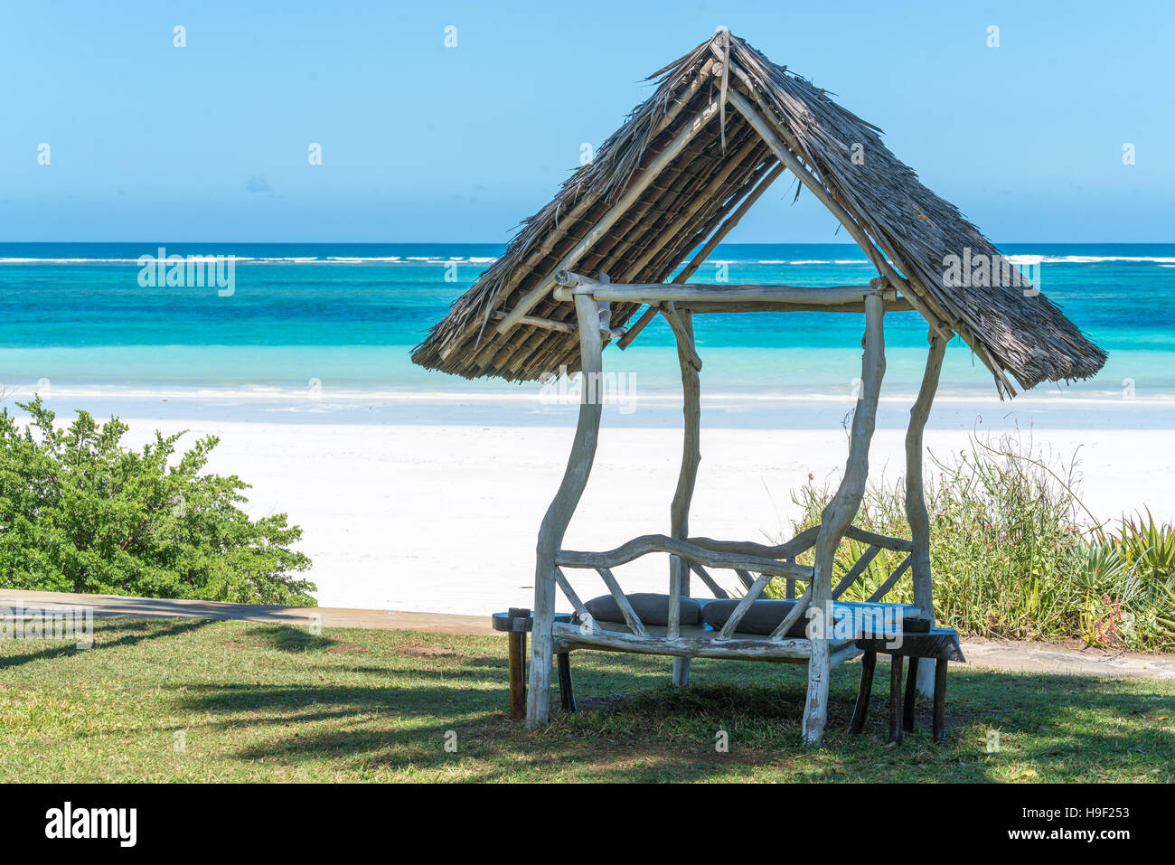 A shaded resting place with a thatched roof along Diani Beach Stock Photo