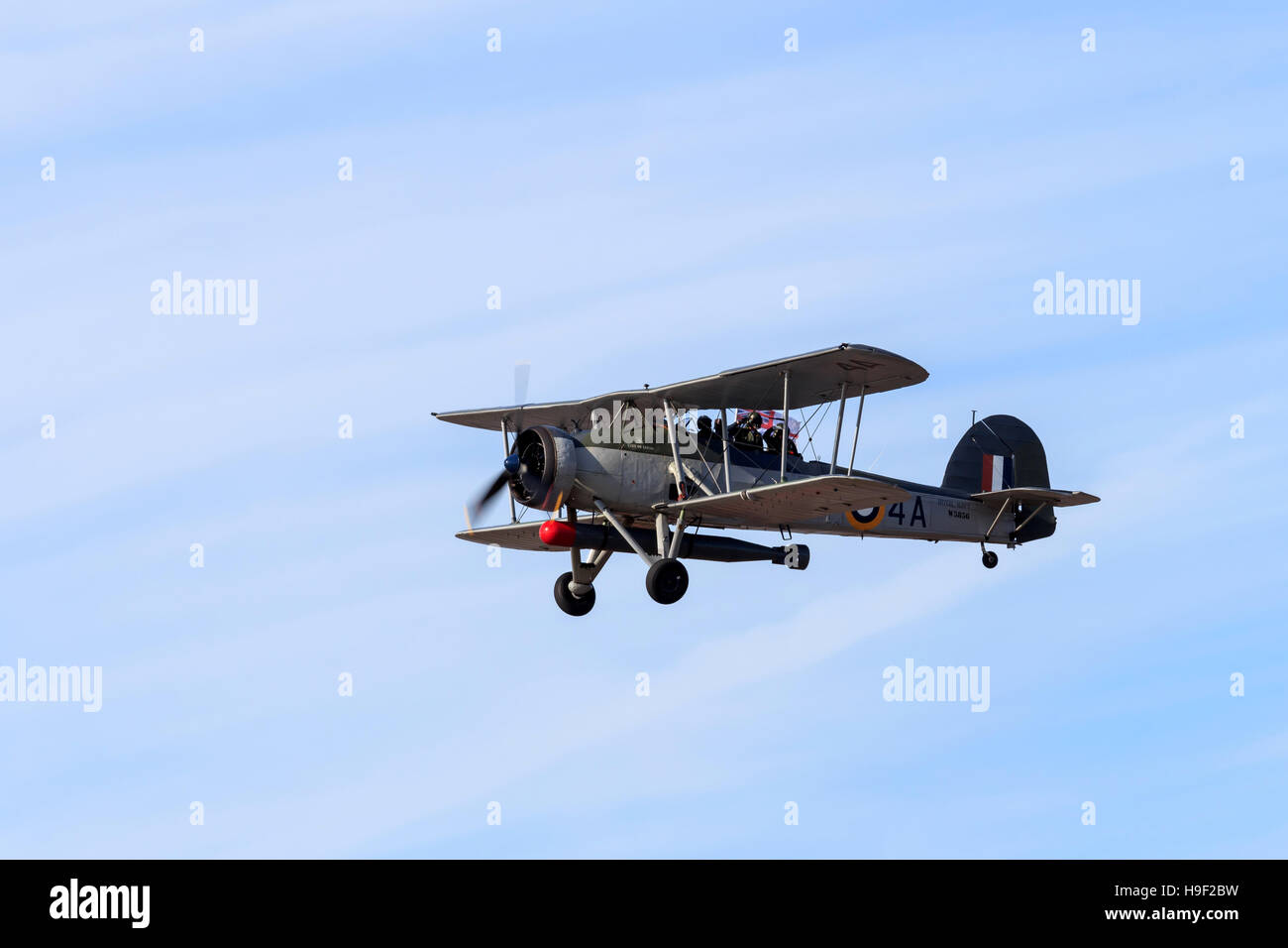 Royal Navy Fairey Swordfish biplane with two air crew saluting on fly