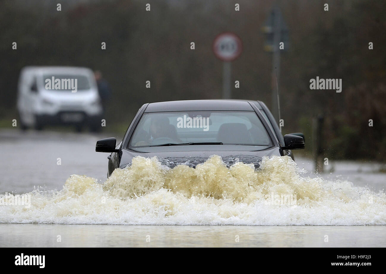 A car makes its way through floodwater in Sileby in Leicestershire after heavy rain overnight, as wind and rain continue to blight parts of Britain threatening further travel chaos after torrential downpours caused flash-flooding and disruption across most of the country. Stock Photo