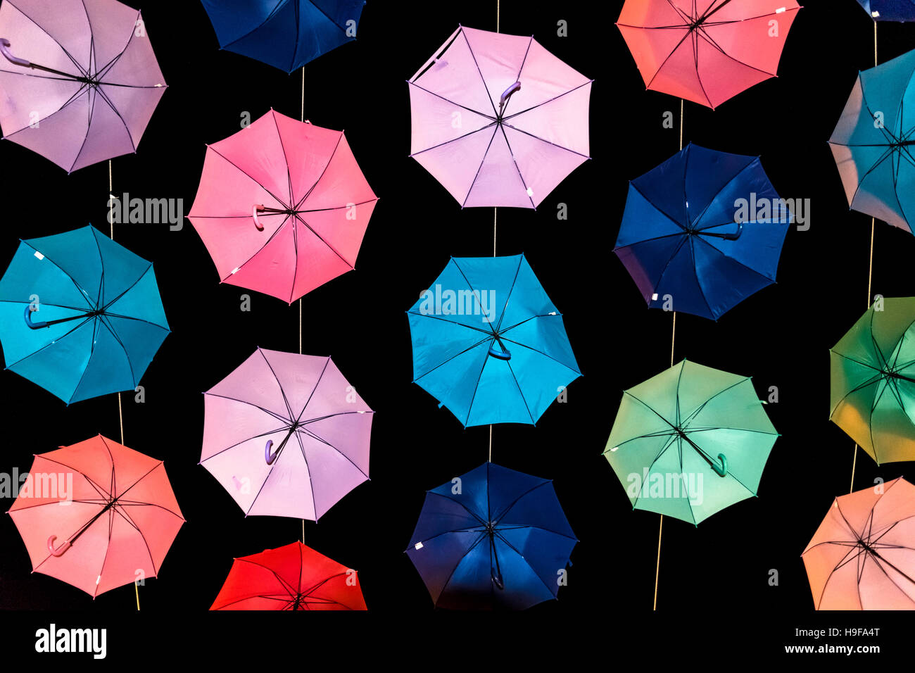 Colored open umbrellas on a black background Stock Photo - Alamy