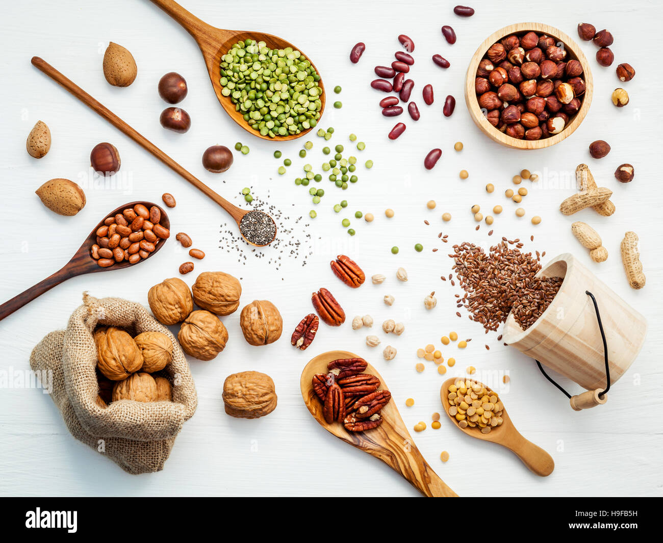 Bowls and spoons of various legumes and different kinds of nuts Stock Photo