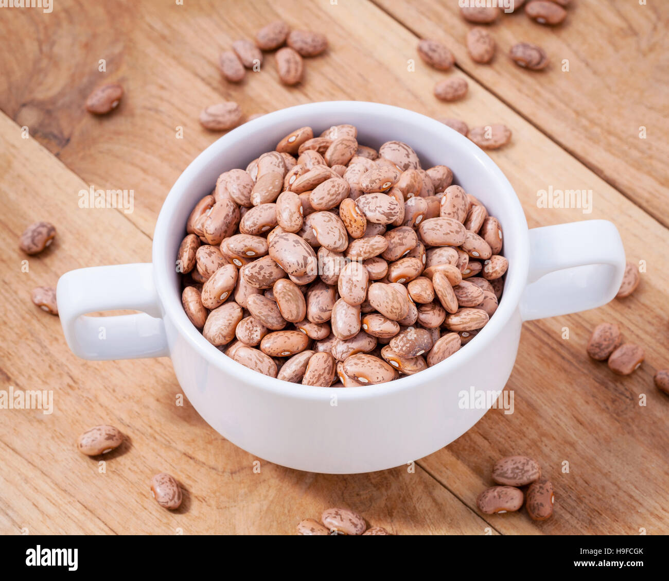 Close up Brown pinto beans in white bowl on wooden background. S Stock Photo