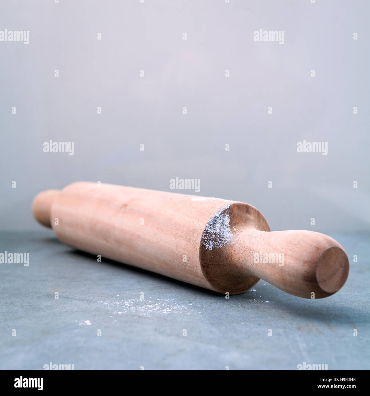 Kitchen rolling pin with flour on dark background selective focu Stock