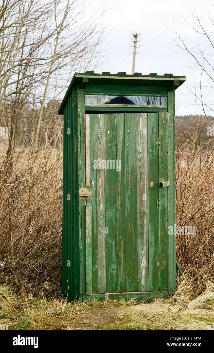 Green outdoor toilet near the field, unsanitary concept village Stock Photo