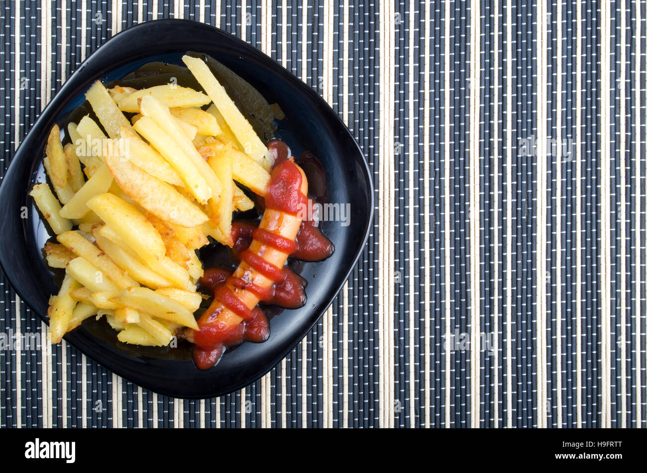 Top view of the Russian national dish - fried sausage with tomato ketchup and a side dish of fried potatoes Stock Photo