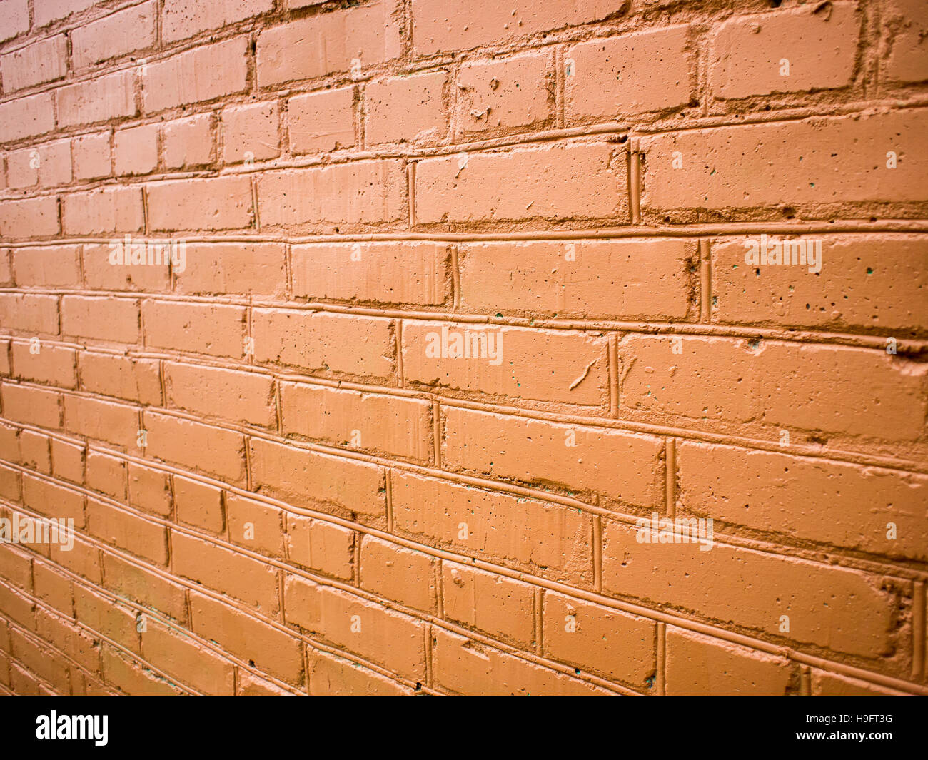 View angle on the brick wall, painted in red paint Stock Photo