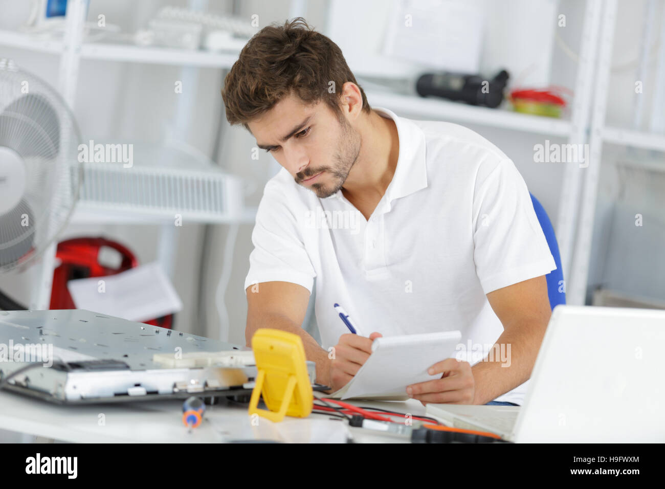 young engineer taking notes while developping new induction hobs Stock