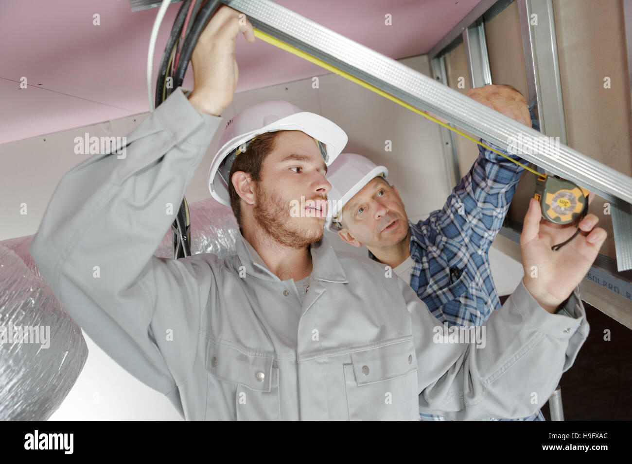team of electrician fitting an air conditioning unit Stock Photo Alamy