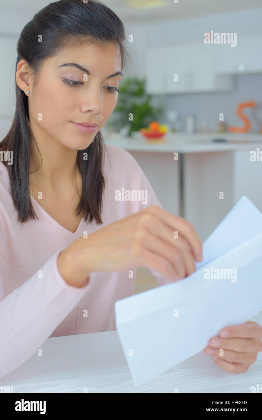 young woman opening a letter Stock Photo