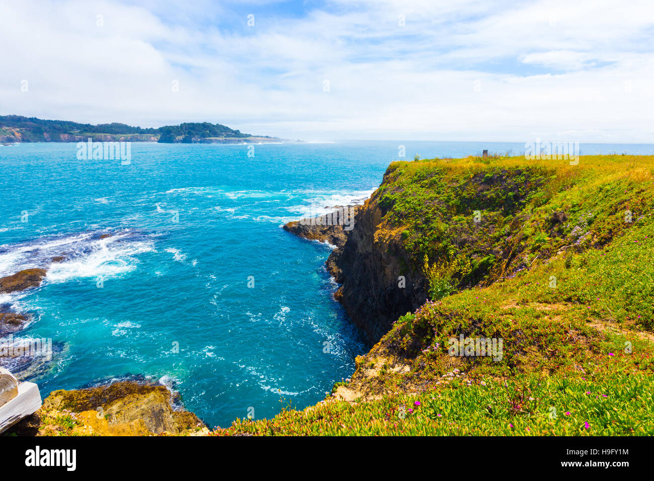 Beautiful rocky coastline and churning ocean below cliffs near Mendocino Bay on sunny day in California. Horizontal Stock Photo