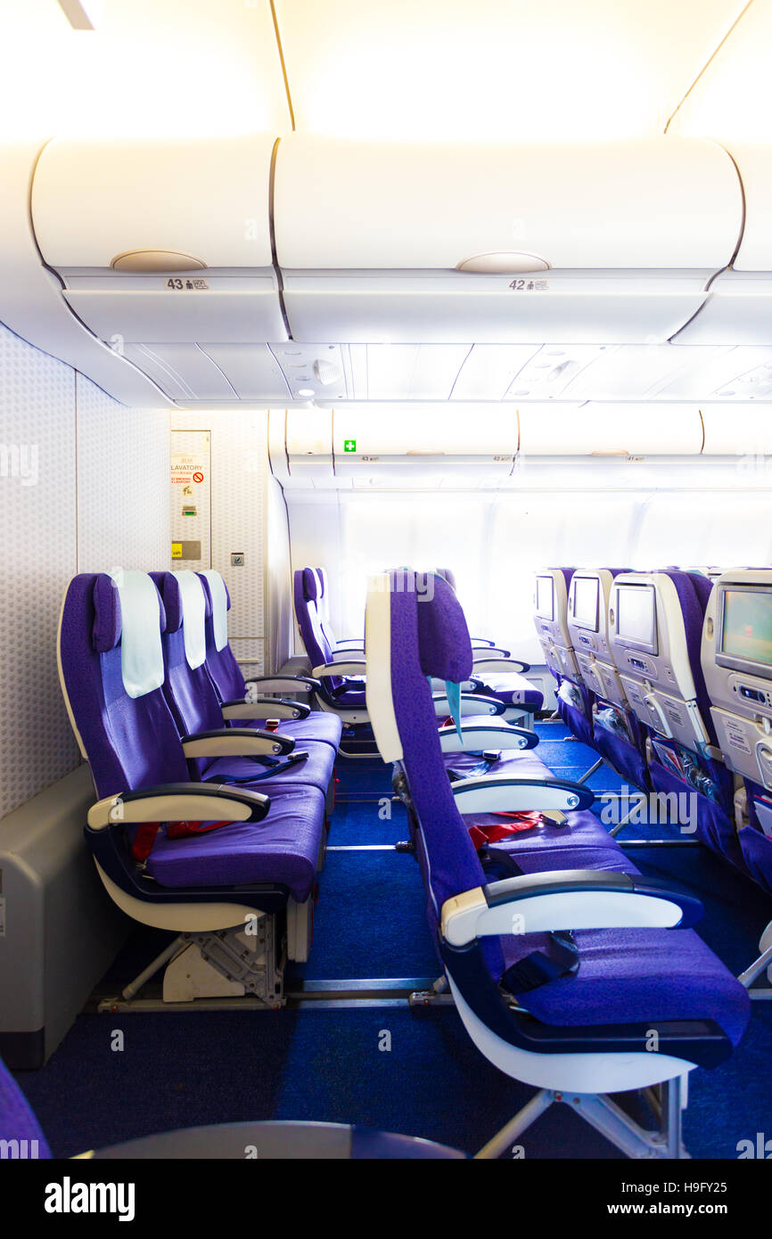 Empty non reclining last rows of economy class on airplane with purple