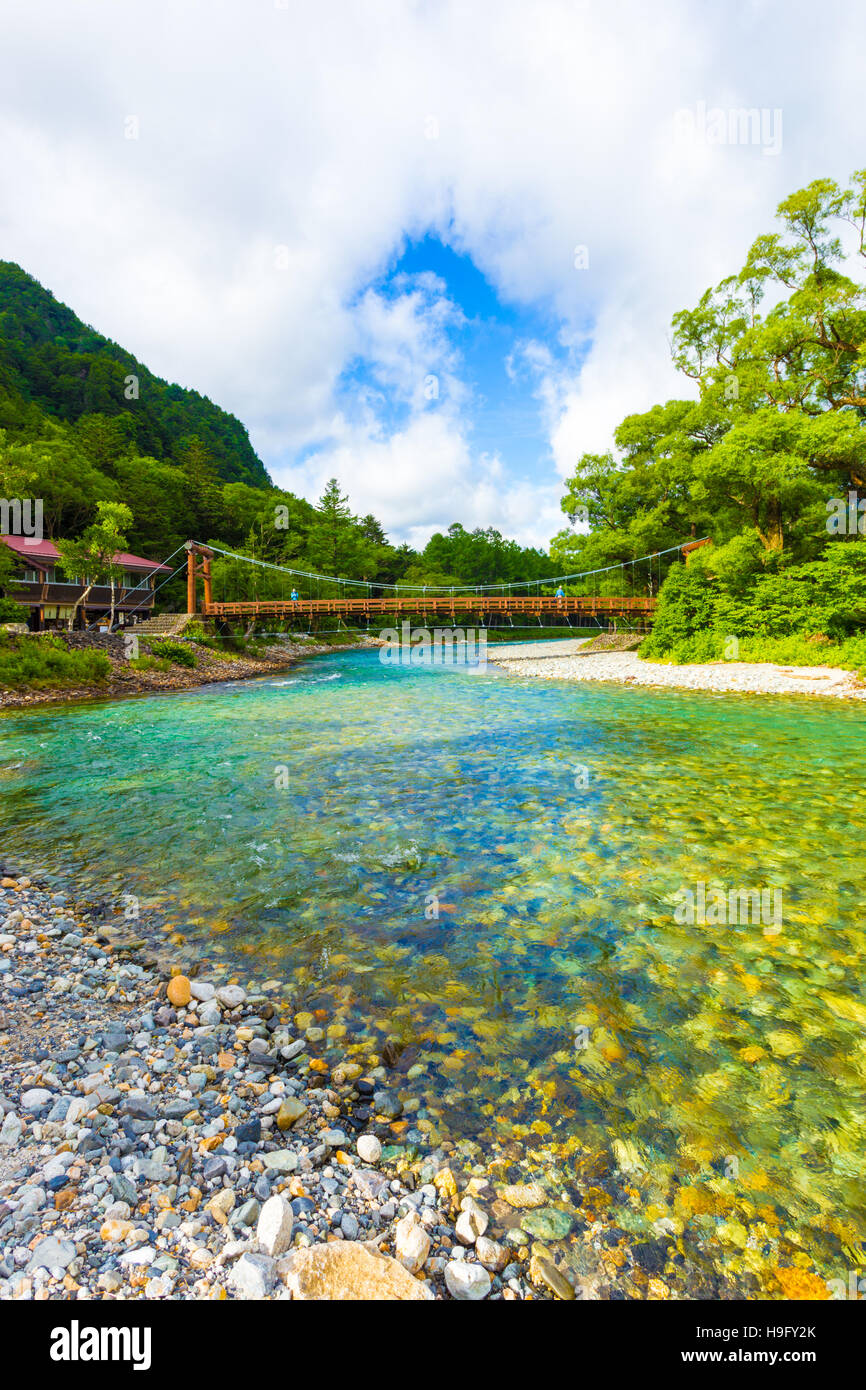 Blue sky breaks through clouds above Kappa Bridge over the clear alpine  waters of the Azusa River at morning in Kamikochi Stock Photo - Alamy