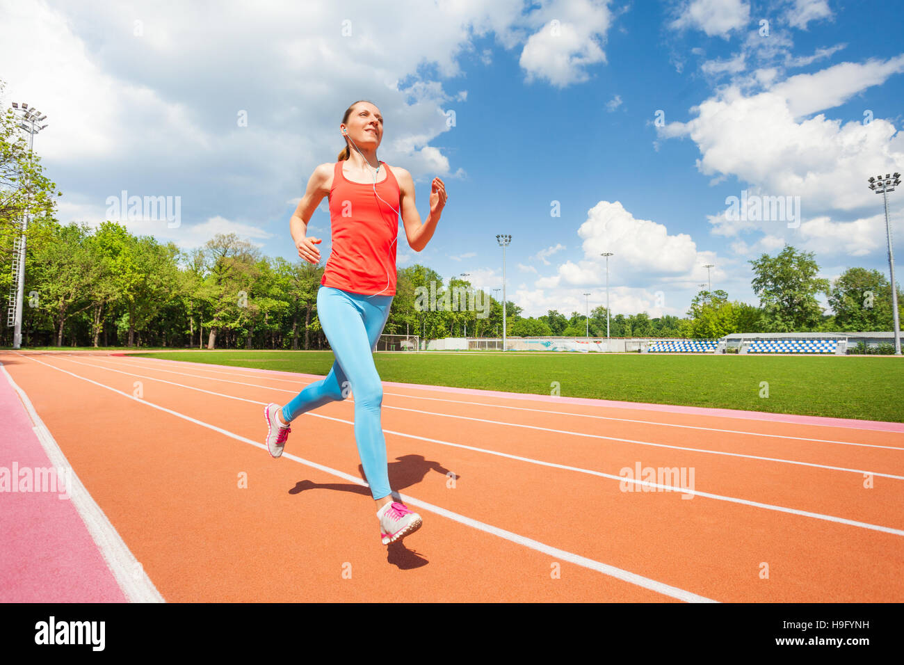 Active female runner working out at stadiums track Stock Photo