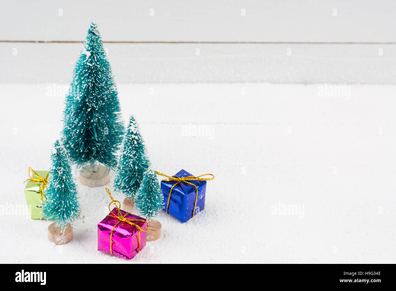 Artificial christmas trees with snow and gift boxes for background with