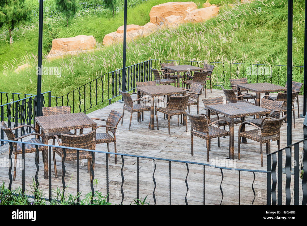 The wood table on natural outdoor of a restaurant with tree and cloudy